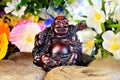 Hotei Budai fun in the garden flowers. Hotei, Budai Ã¢â¬â in Japanese mythology the gods of happiness, God of communication, joy and Royalty Free Stock Photo